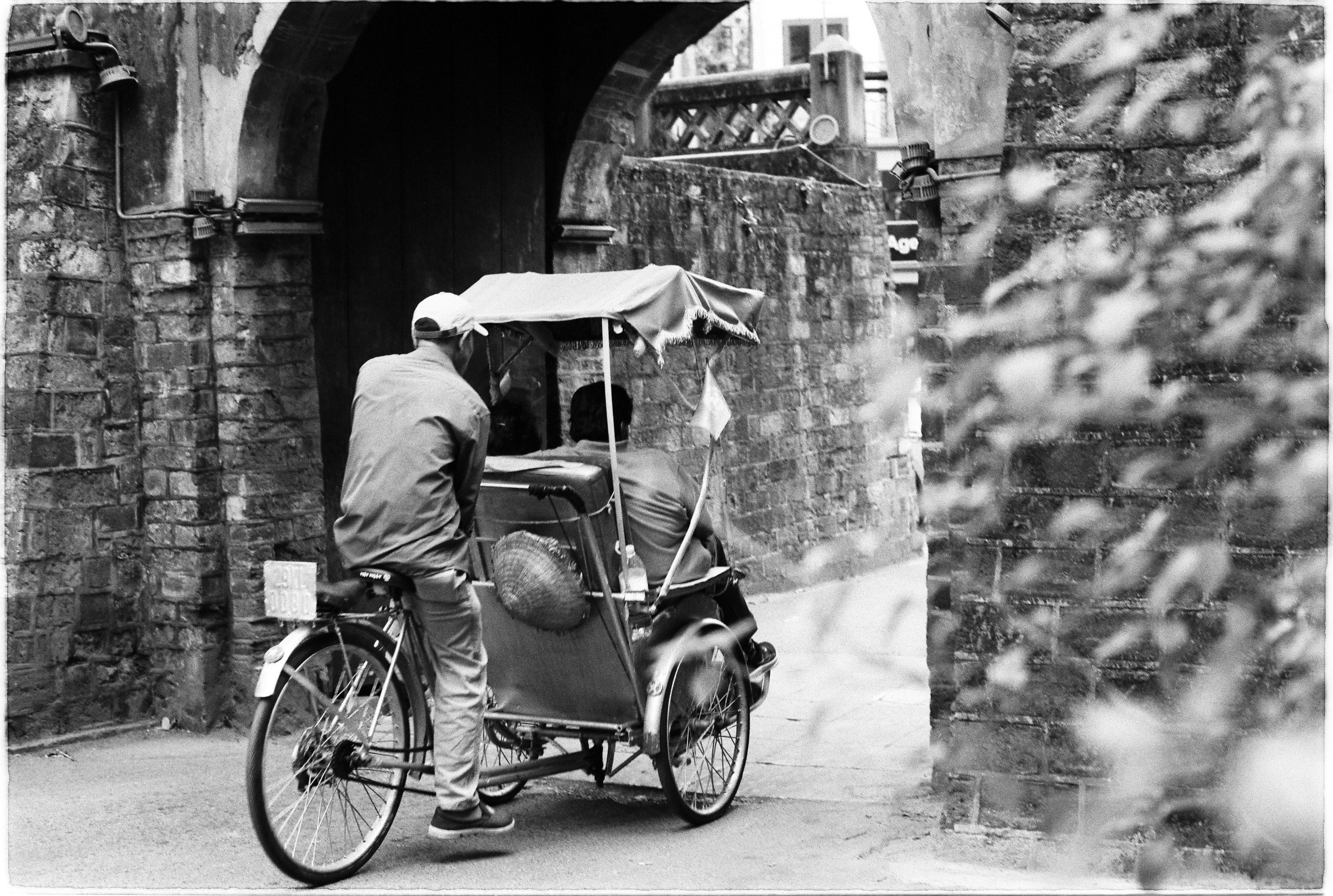 Vintage Rickshaw Ride through Historic Archway · Free Stock Photo