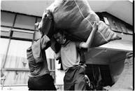 Workers Lifting Heavy Sack in Warehouse