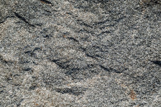Detailed close-up of rough granite rock texture, showcasing natural patterns.