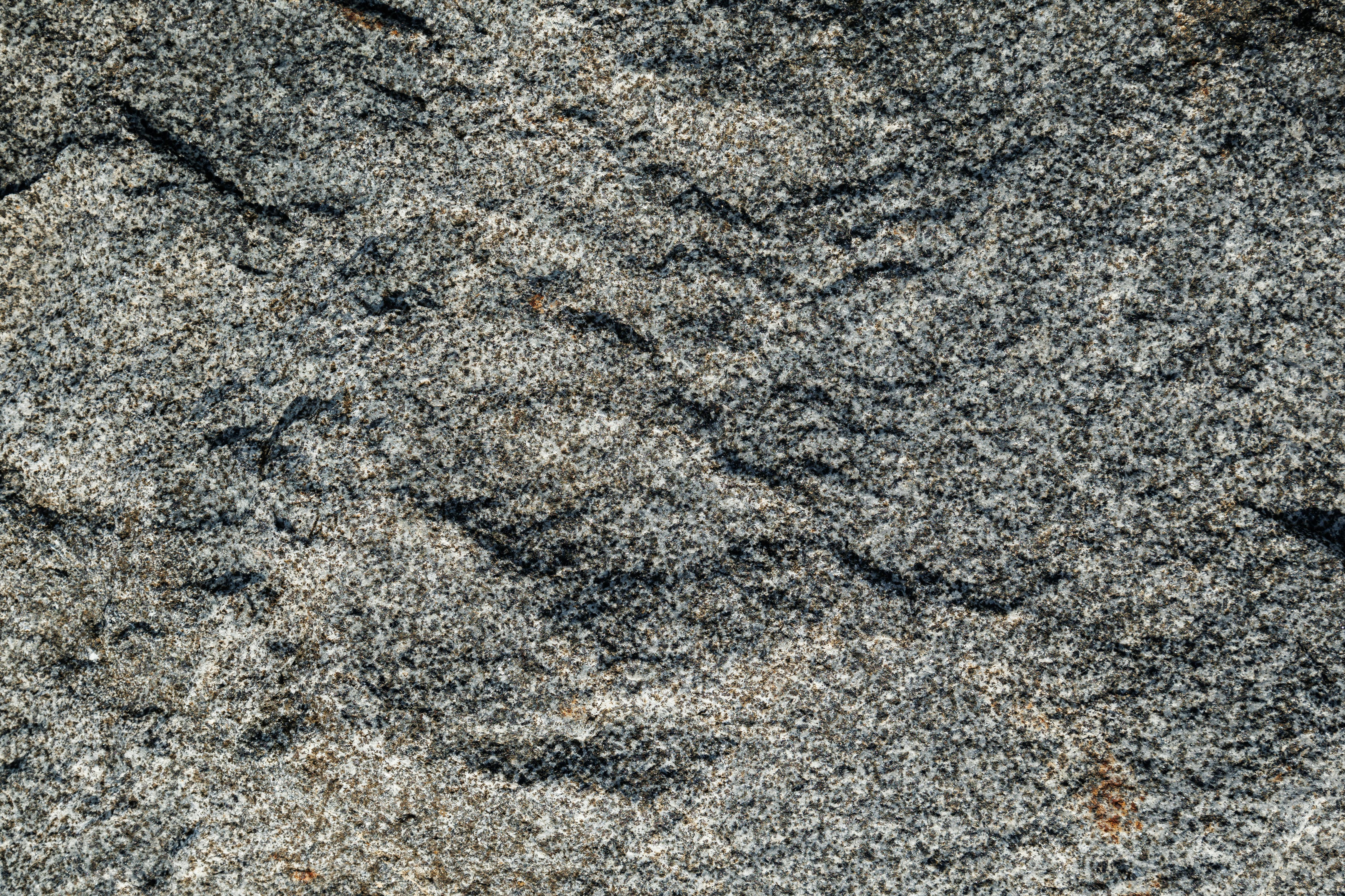 Free Detailed close-up of rough granite rock texture, showcasing natural patterns. Stock Photo
