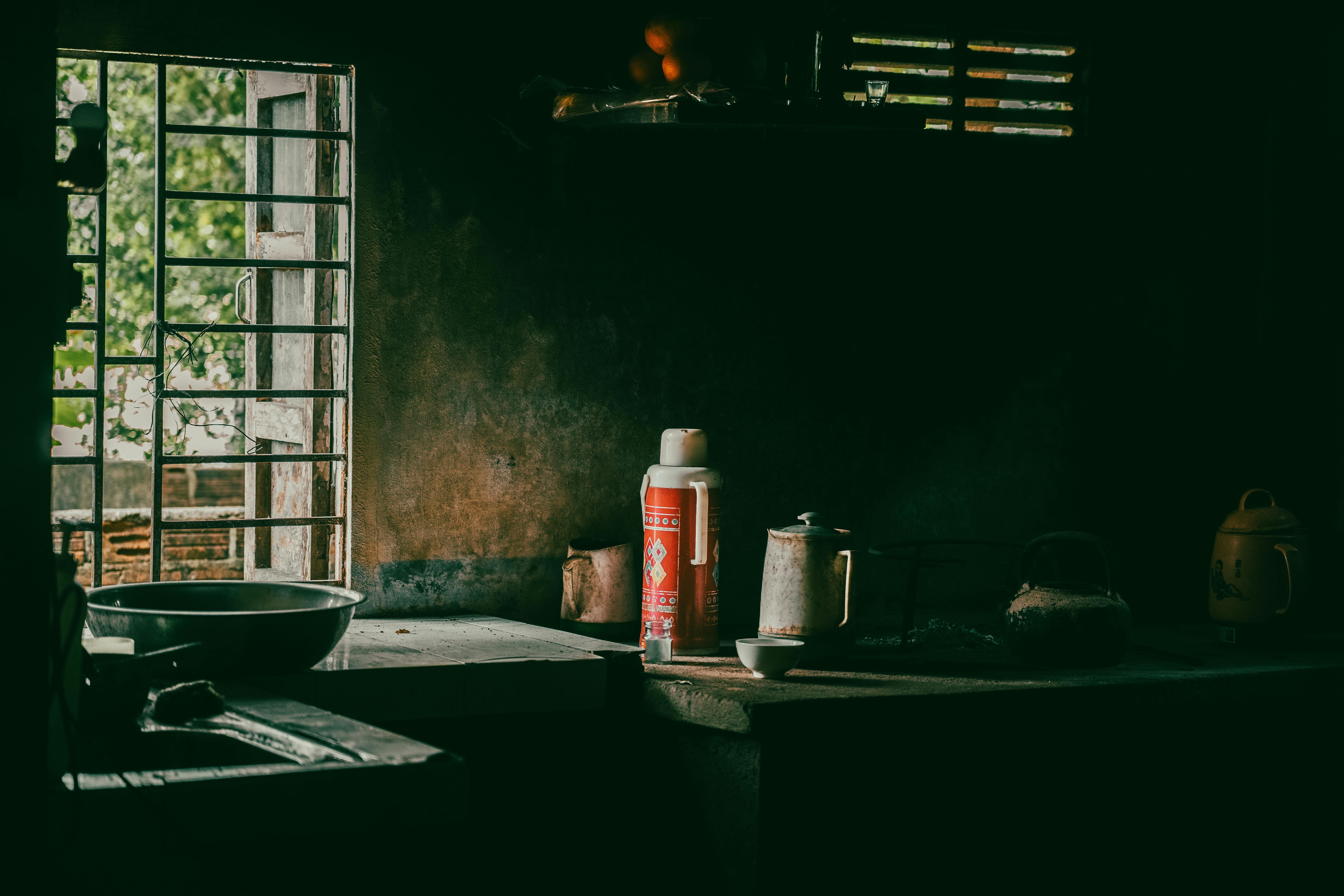 無料 ヴィンテージの調理器具と控えめな照明が備わった素朴なキッチンは、ノスタルジックで雰囲気のあるシーンを作り出します。 写真素材