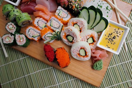 Free Vibrant sushi platter featuring various rolls, sashimi, and garnishes, ideal for culinary themes. Stock Photo