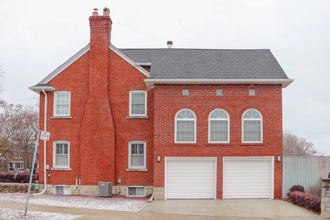 Back of a house with a chimney and garages