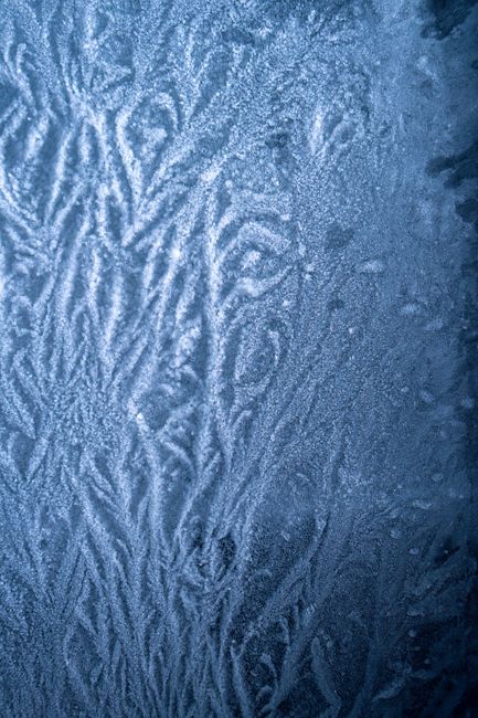 Captivating ice texture featuring intricate, natural patterns in a cool blue hue, ideal for backgrounds.