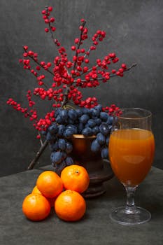 Elegant still life featuring vibrant fruits and berries arranged on a dark backdrop.