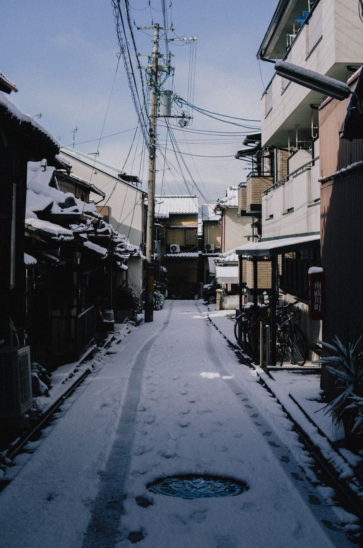 A quiet snow-covered alley in Kyoto showing traditional architecture in winter