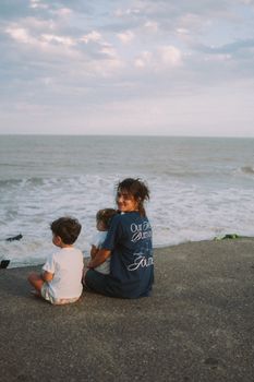 A serene moment of a family sitting by the ocean, enjoying the waves.