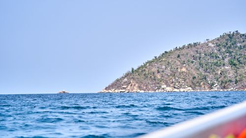 Free Breathtaking view of an island surrounded by tranquil blue ocean under a clear sky. Stock Photo
