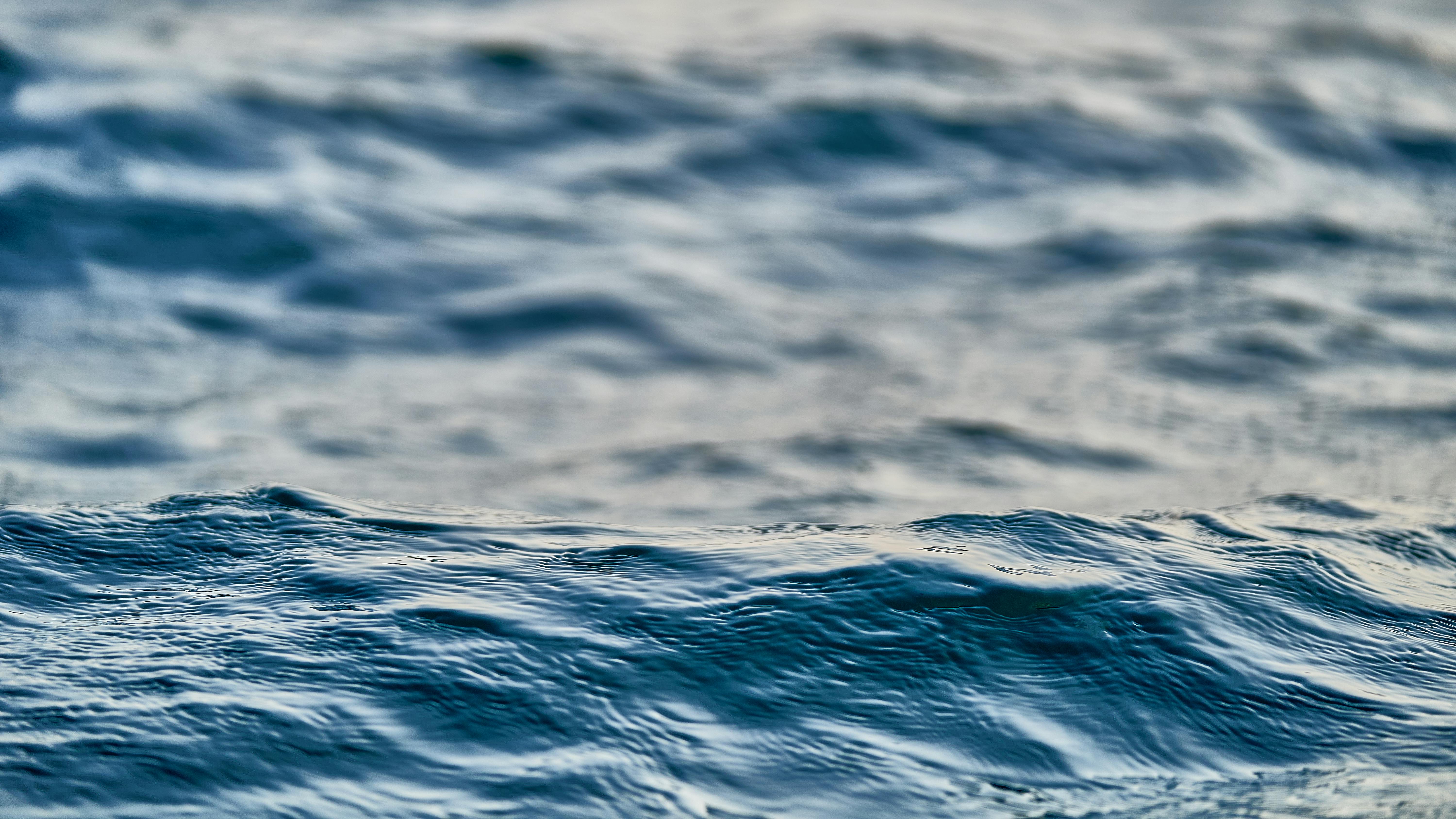 Free A serene close-up of gentle ocean waves with a soft, calming effect captured at twilight. Stock Photo