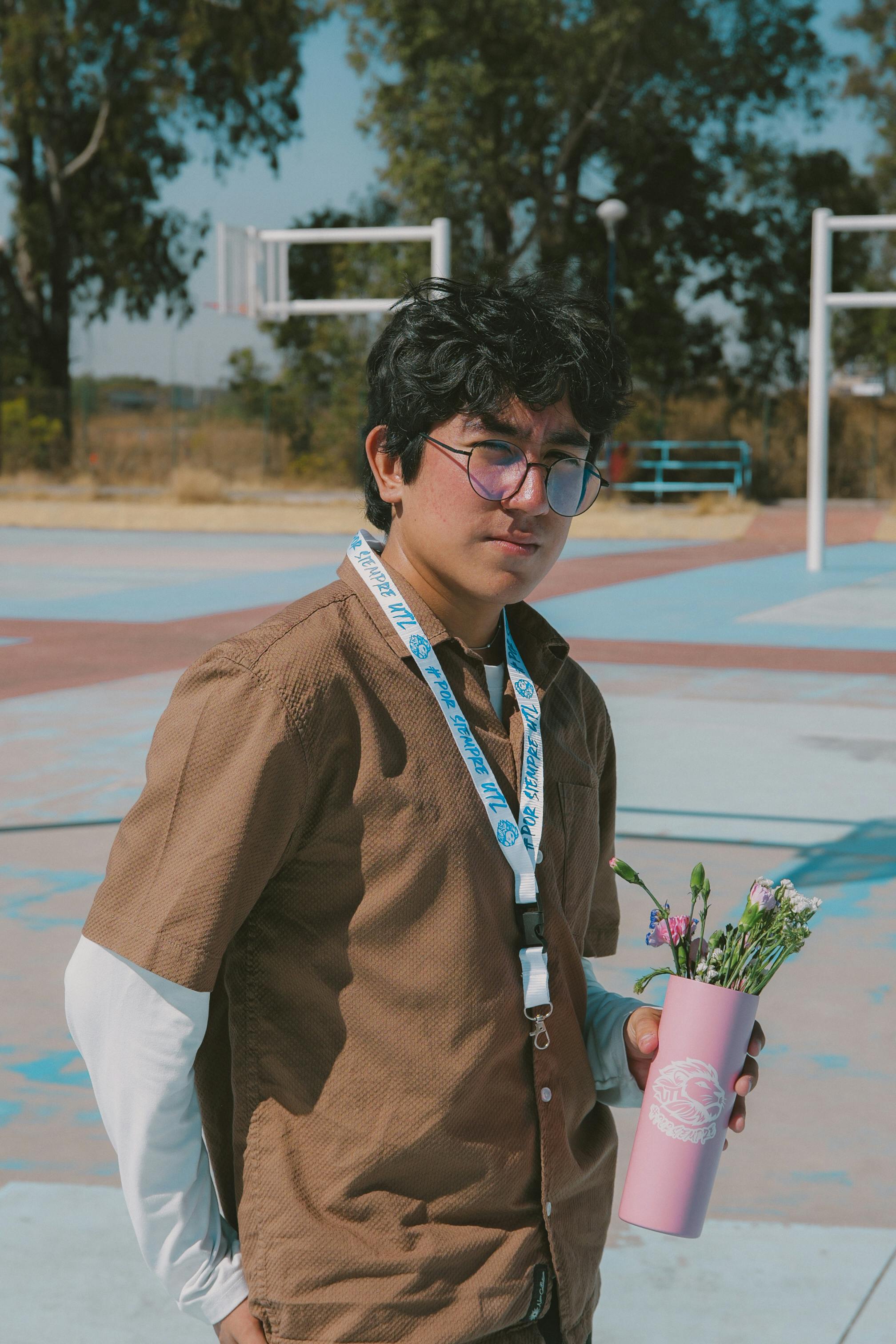 無料 メキシコのレオンの屋外で、花を持って晴れた日を楽しむ気楽な若い男性。 写真素材