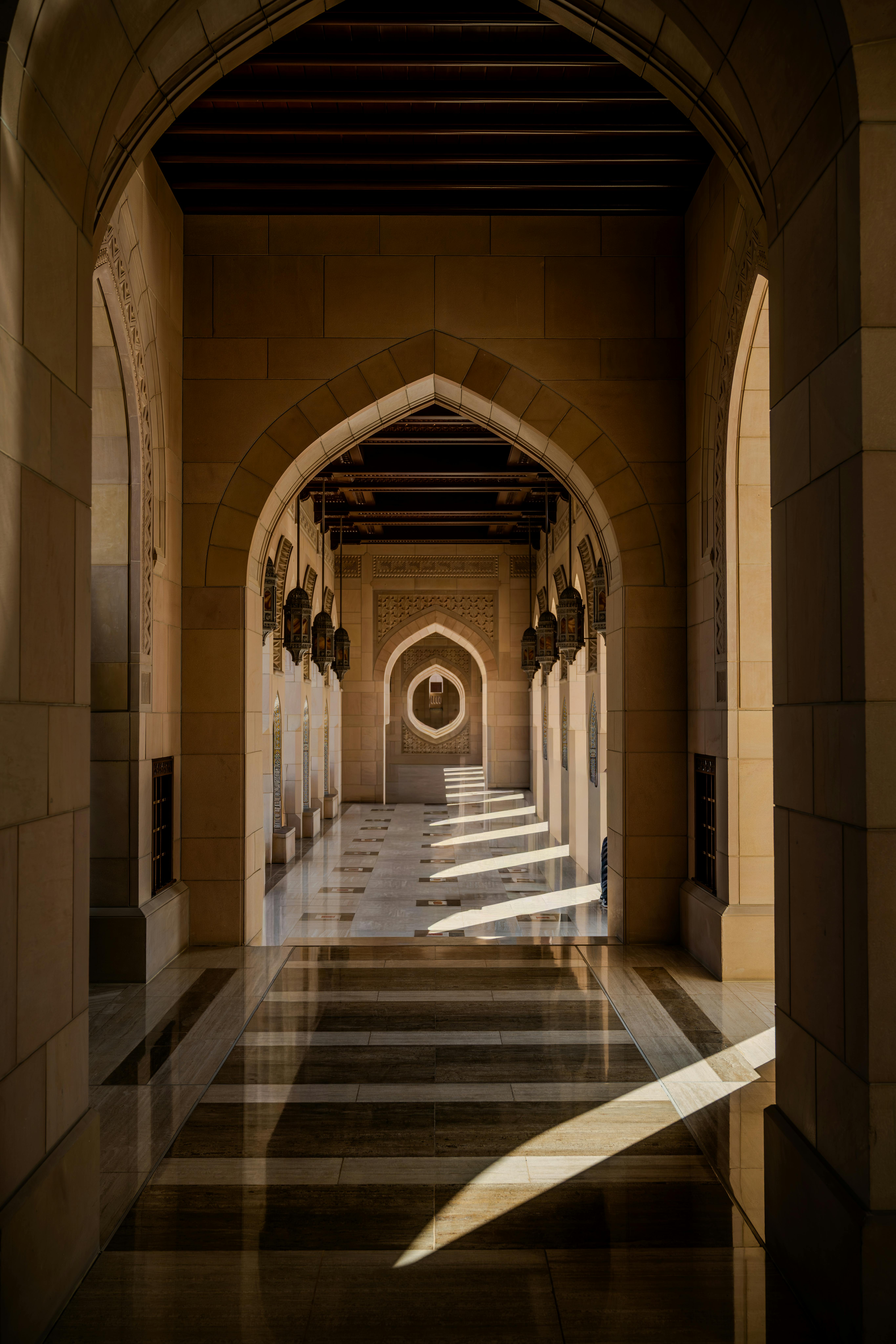 無料 オマーンのマスカットにある、複雑なアーチと影を特徴とする見事な建築回廊。 写真素材