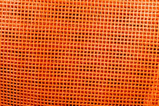 Close-up of an orange plastic mesh texture suitable for backgrounds and design.