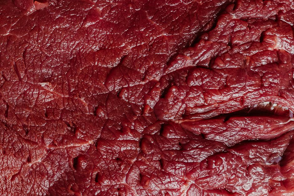 Detailed close-up of raw beef meat showcasing its rich texture and marbling.