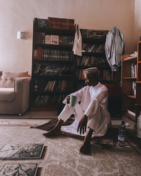 A person in traditional attire enjoys quiet solitude in a Kano, Nigeria library.