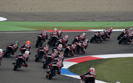 Dynamic shot of motorcyclists racing on a colorful track, showcasing speed and skill.