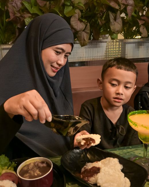 Woman and child enjoying traditional Javanese meal in Indonesia.
