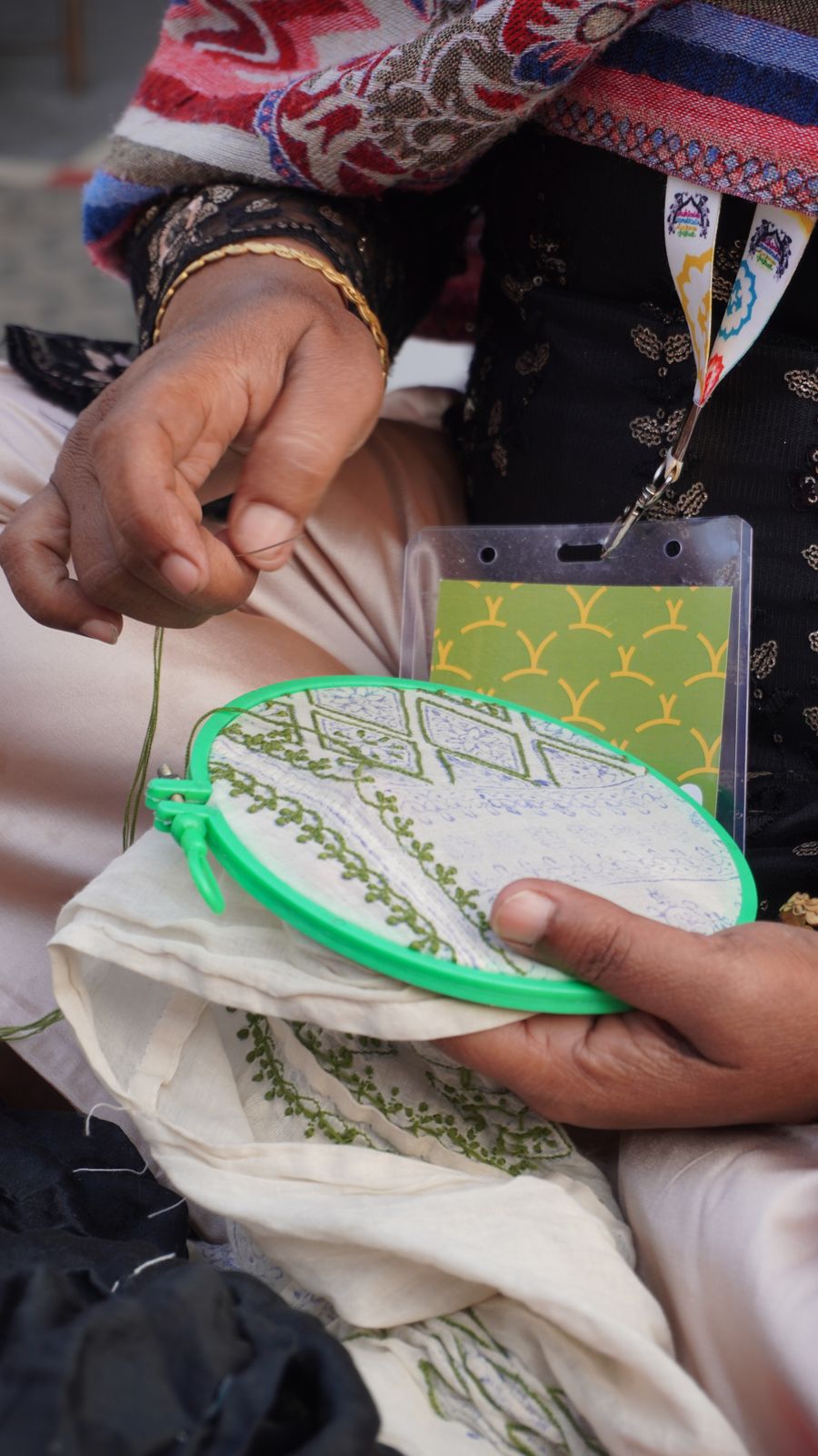 Artisan hand embroidery work on fabric, showing detailed needlework