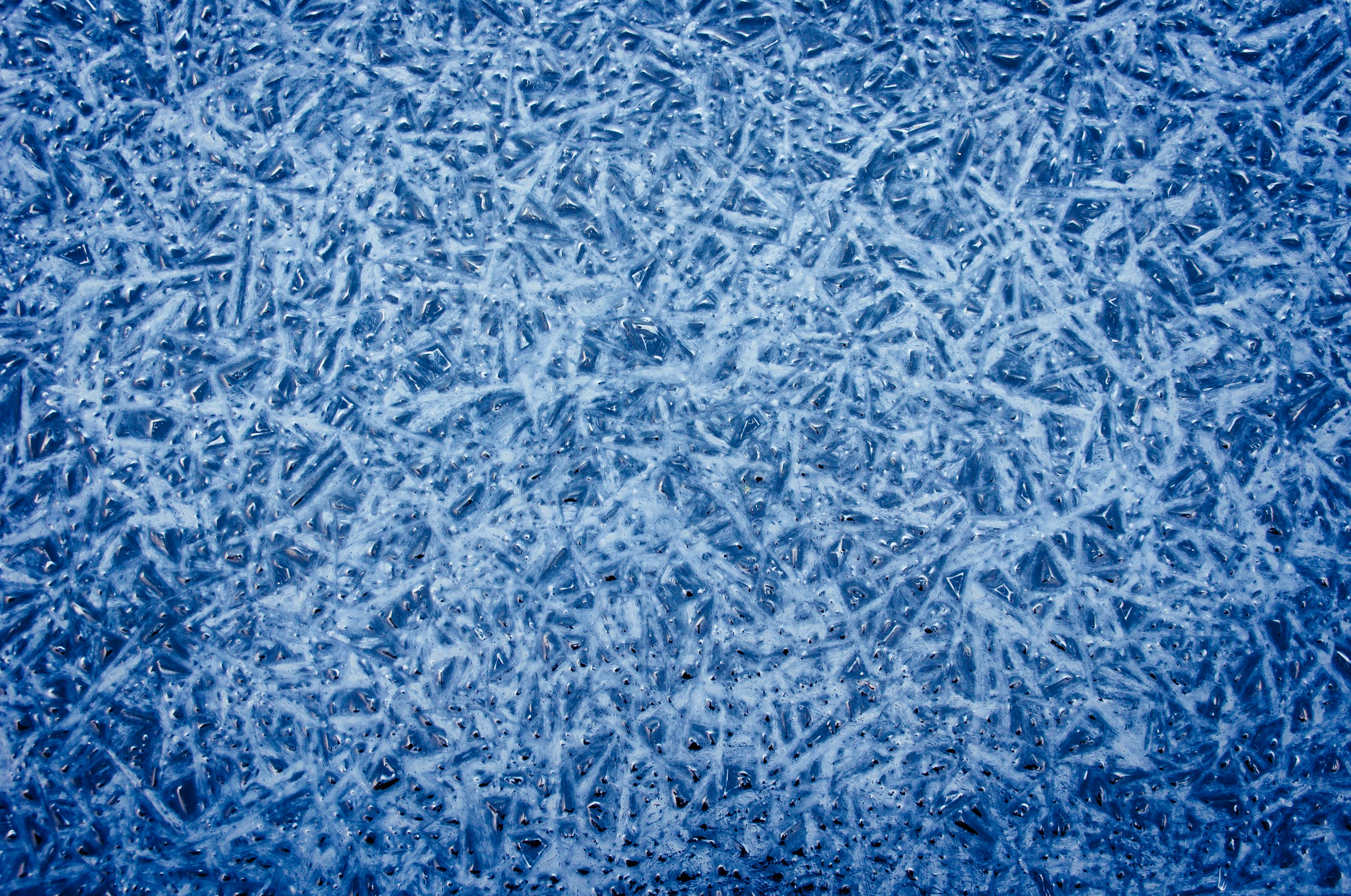 Gratis Primo piano di una superficie ghiacciata strutturata con motivi intricati e sfumature blu. Foto a disposizione