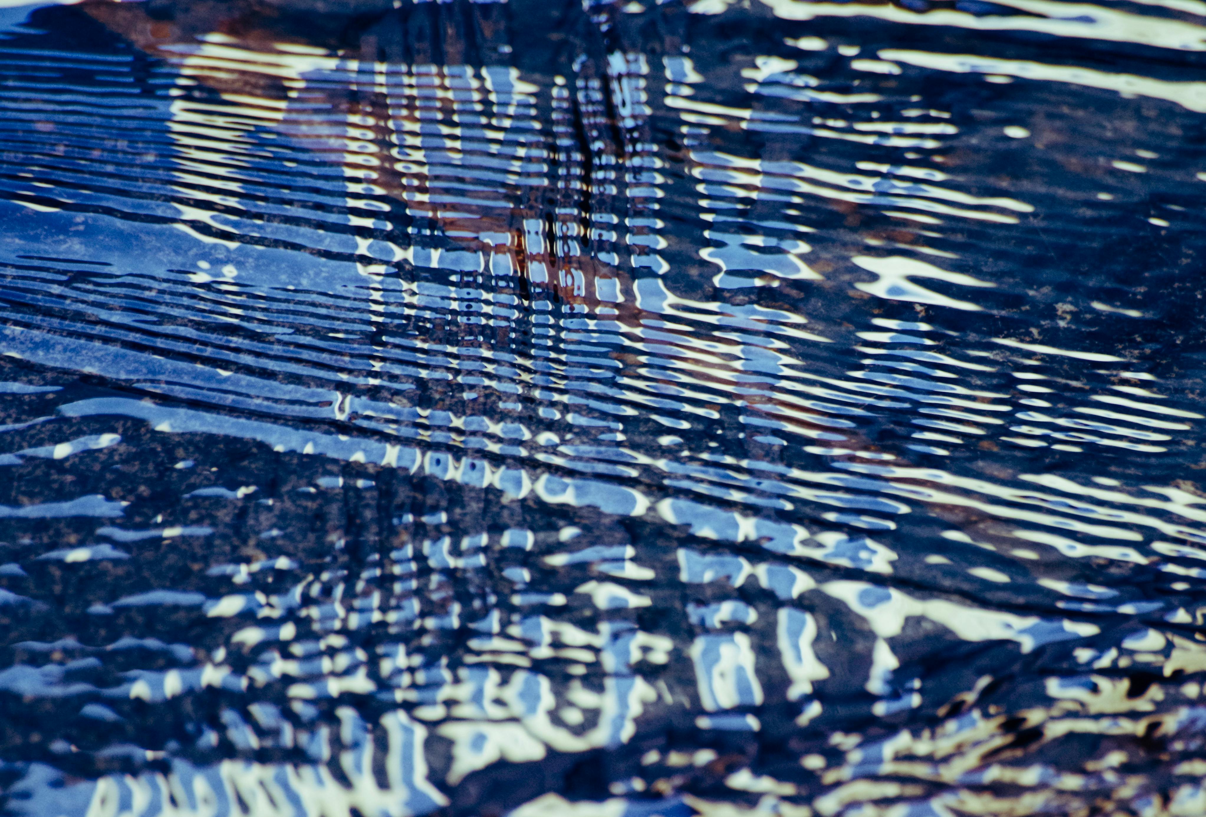 grátis Uma representação artística das ondulações da água, refletindo padrões e cores. Foto profissional