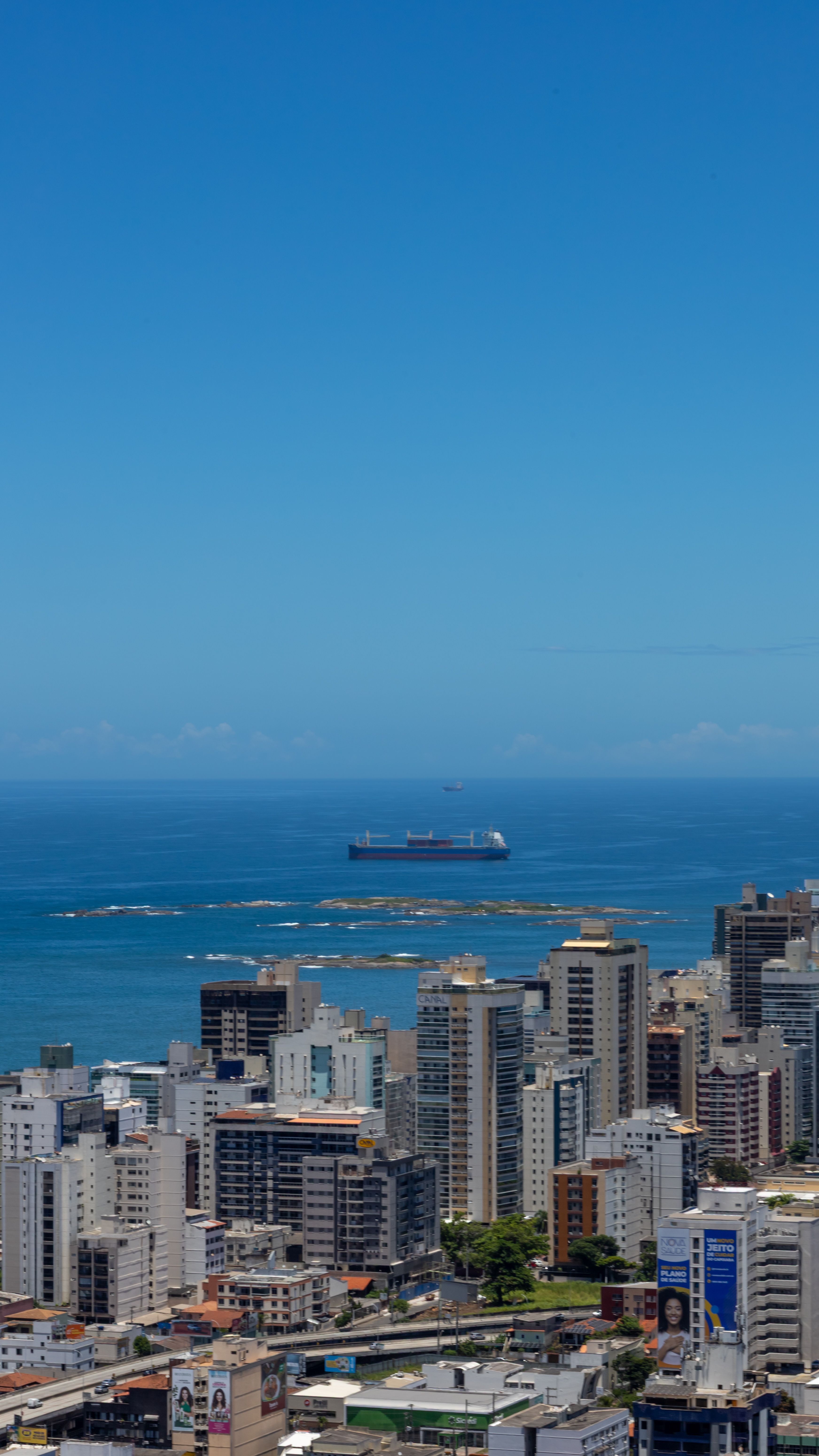 Stunning skyline view of Vila Velha, Brazil, with a distant ocean horizon and shipping vessel.