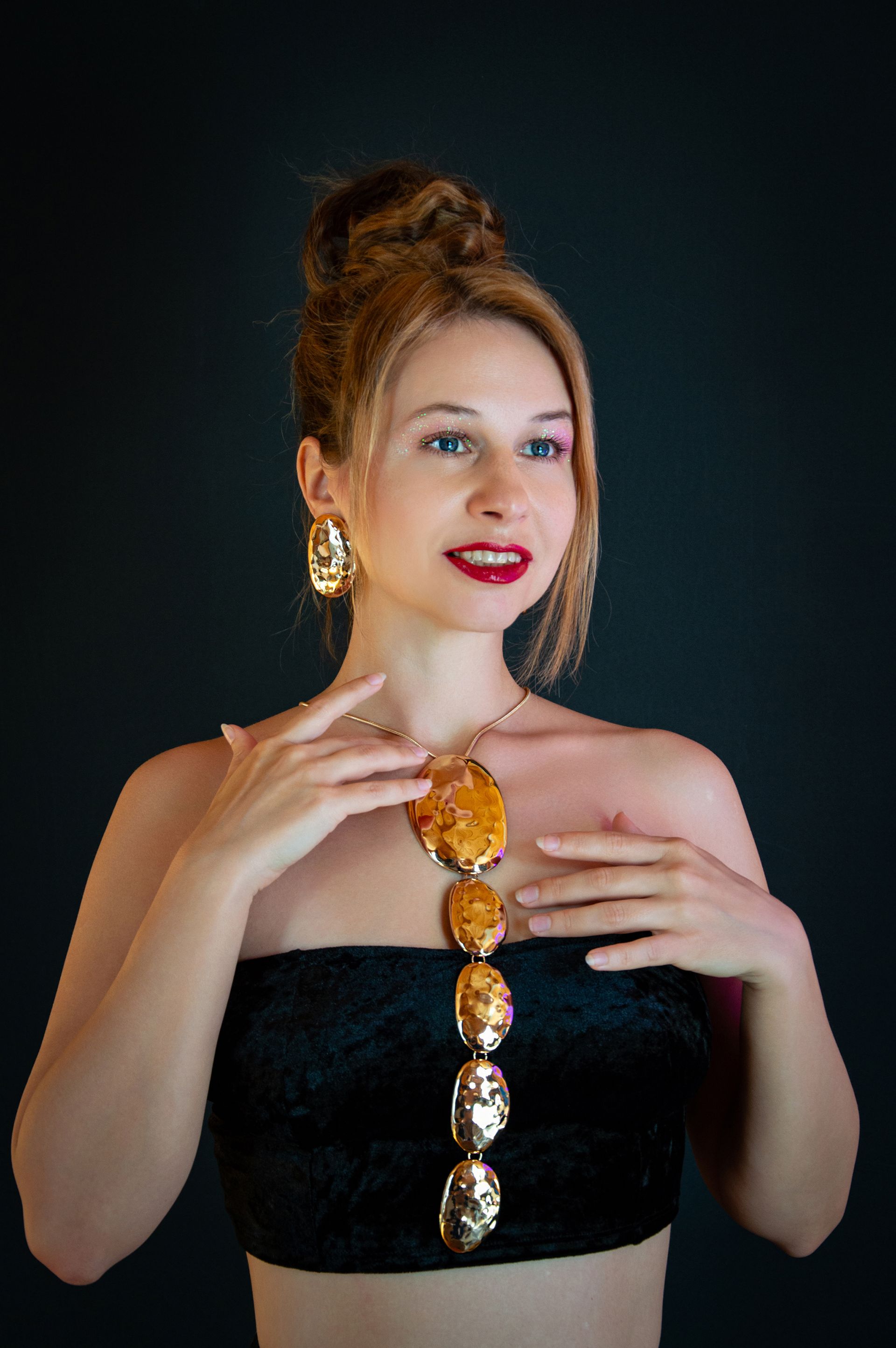 Woman in evening attire with gold jewelry
