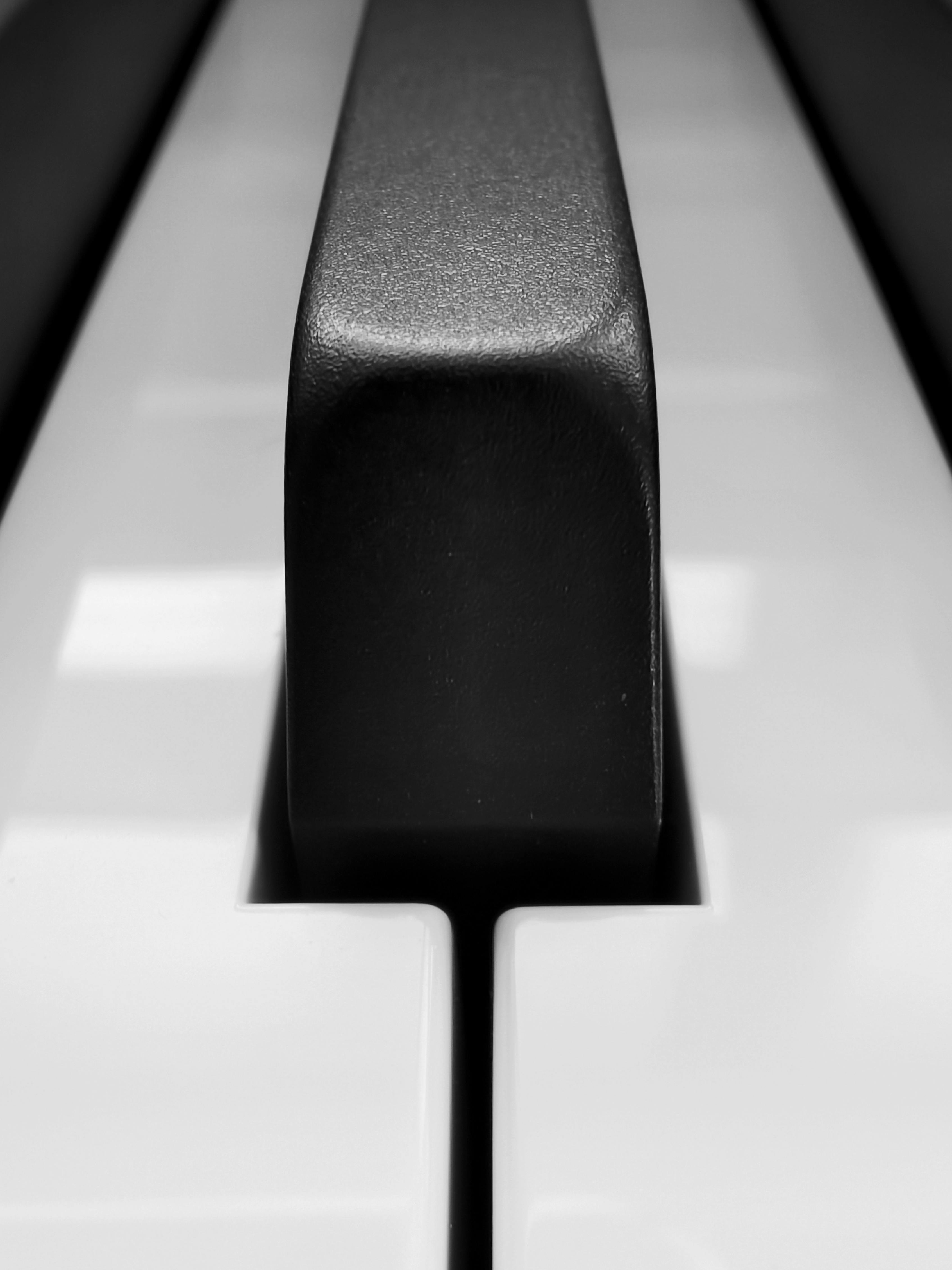 ingyenes Részletes közeli kép egy zongorabillentyűről, amelyen a fekete-fehér billentyűk modern hatást keltenek. Stockfotó