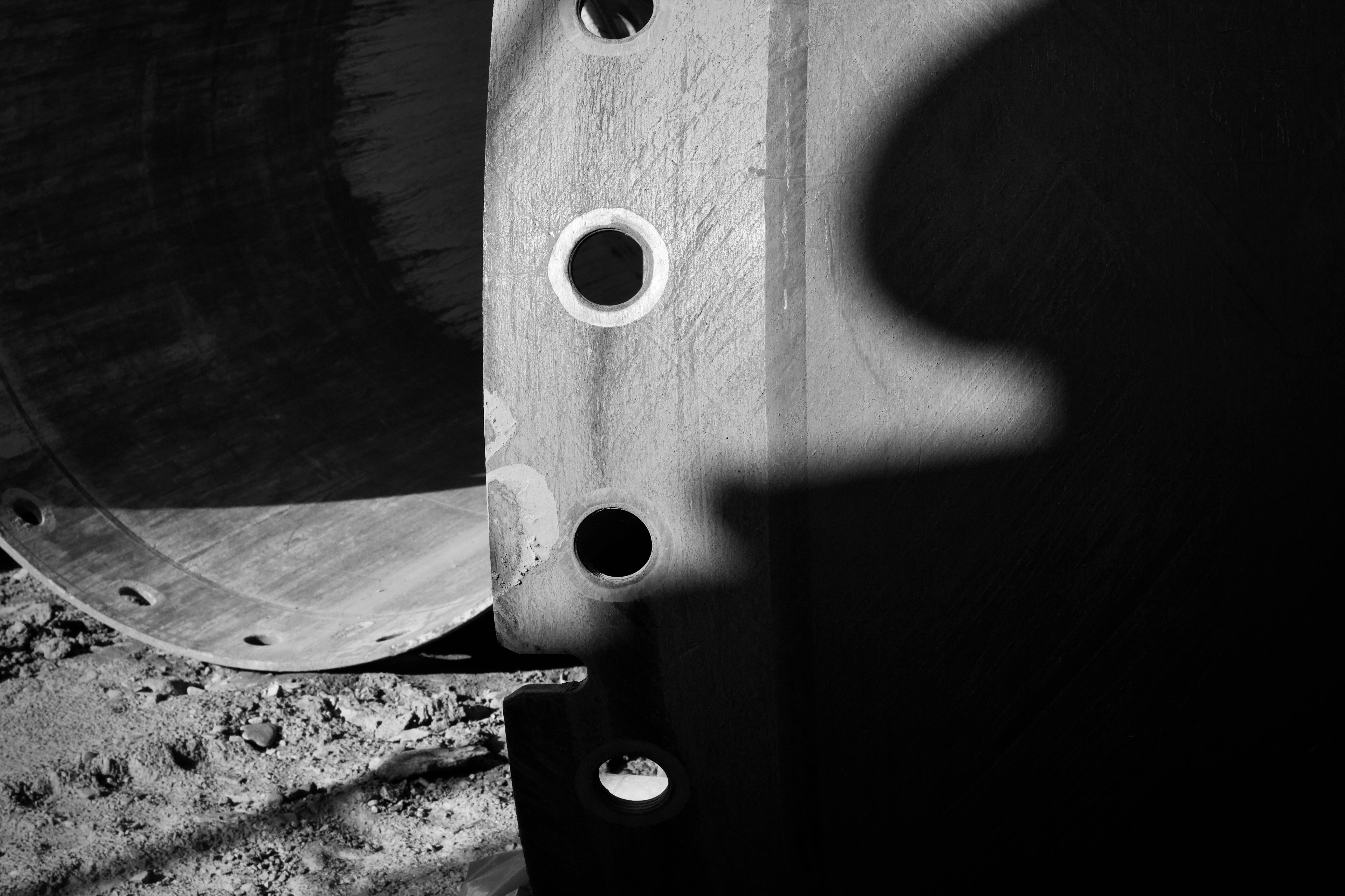 Free Artistic black and white photograph of industrial pipes with dramatic shadows. Stock Photo