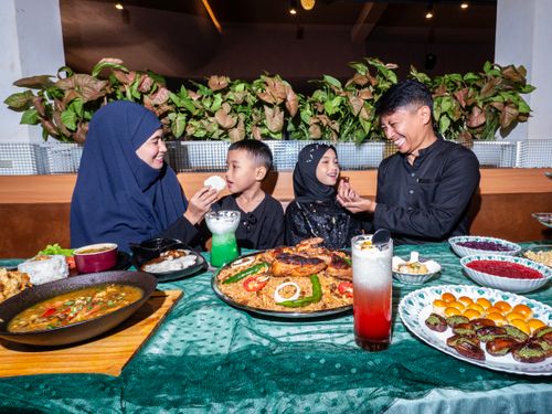Free A joyful family enjoying a festive meal indoors with a variety of traditional dishes on a table. Stock Photo