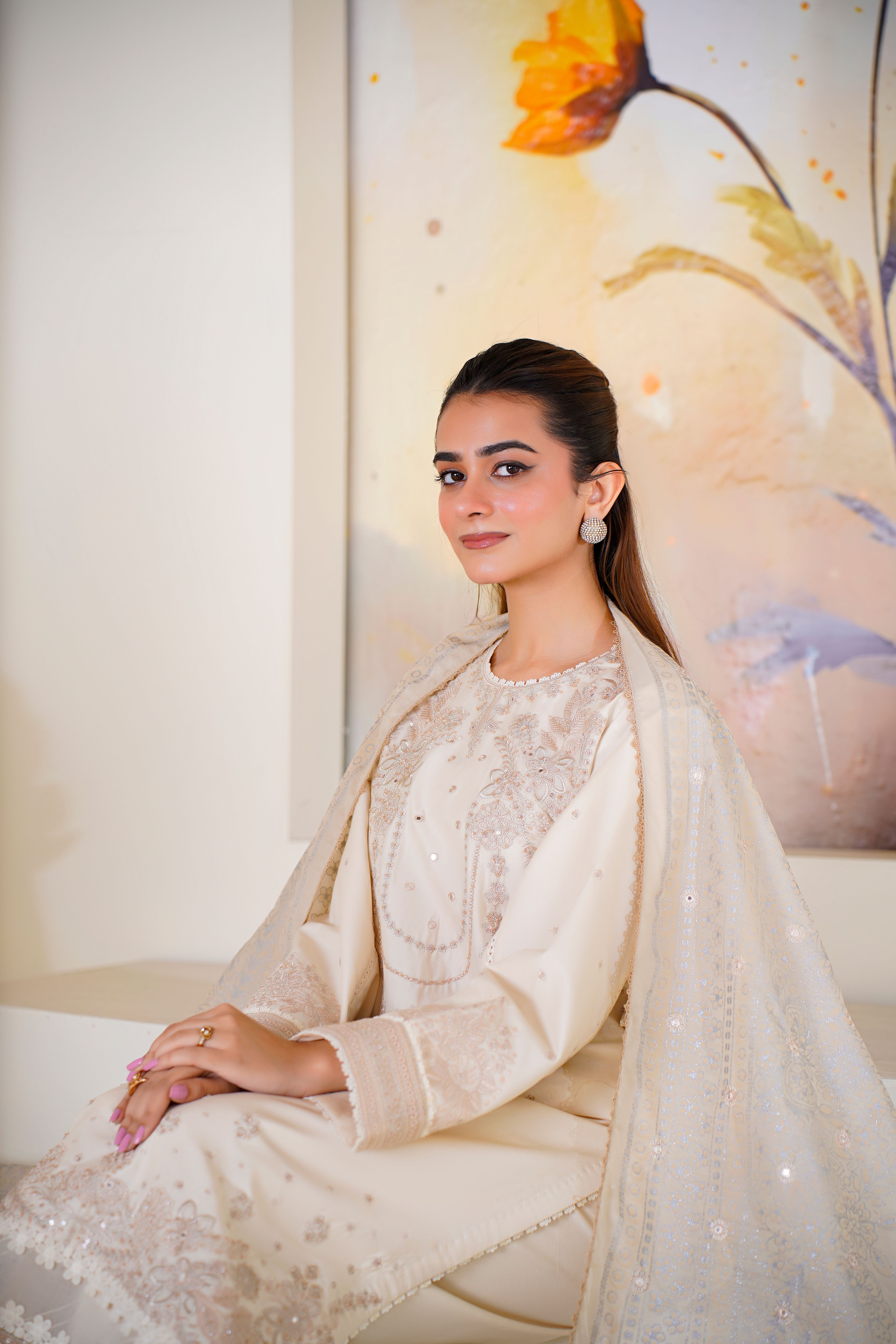 Model in Lahore wearing luxurious embroidered eastern dress, posing indoors.