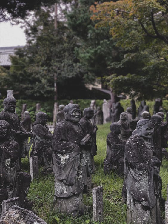 Free Old Buddhist sculptures near forest in park Stock Photo