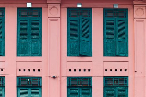 Free Colorful pink facade with teal shutters showcasing vintage colonial architecture. Stock Photo