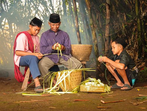 Free A family crafting with palm leaves in a traditional setting in Banten, Indonesia. Stock Photo