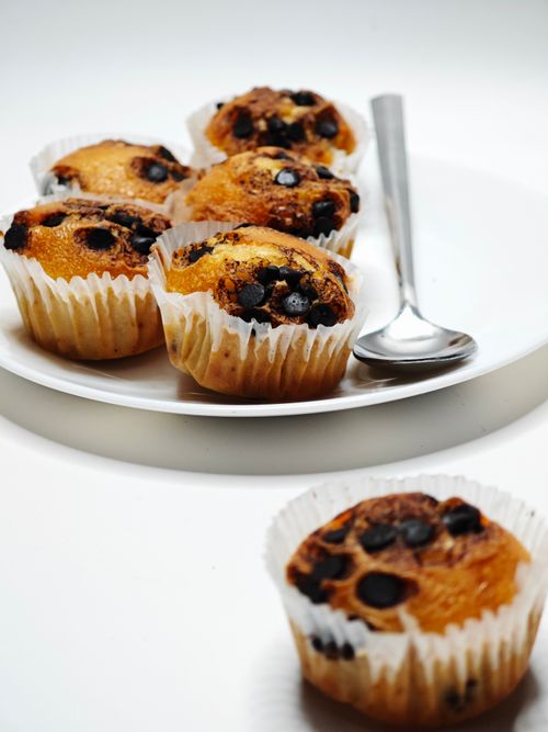 Free Tasty chocolate chip muffins served on a white plate with a spoon. Stock Photo