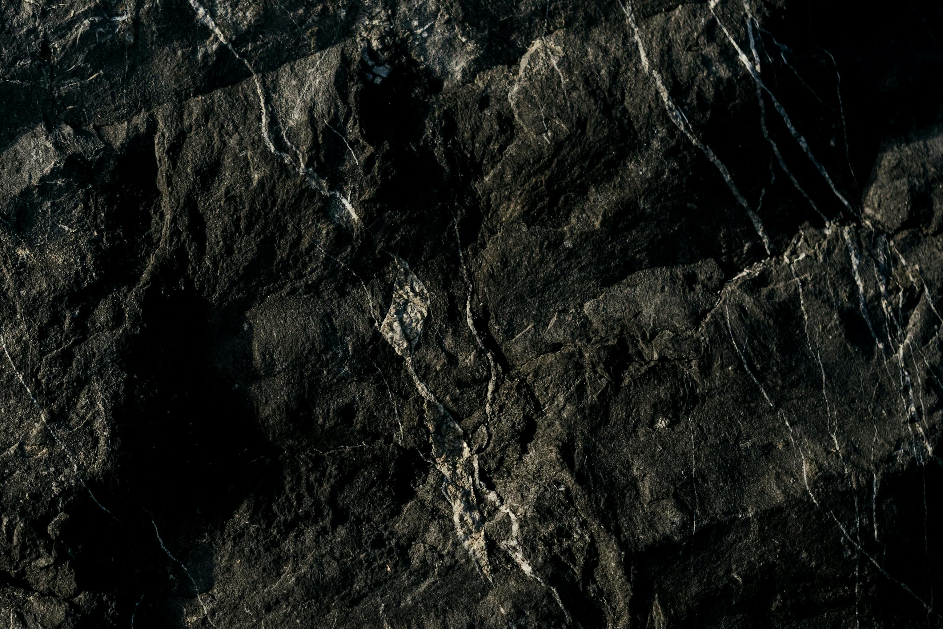 Gratis Primo piano di una superficie in marmo scuro con texture e motivi naturali da utilizzare come sfondo. Foto a disposizione