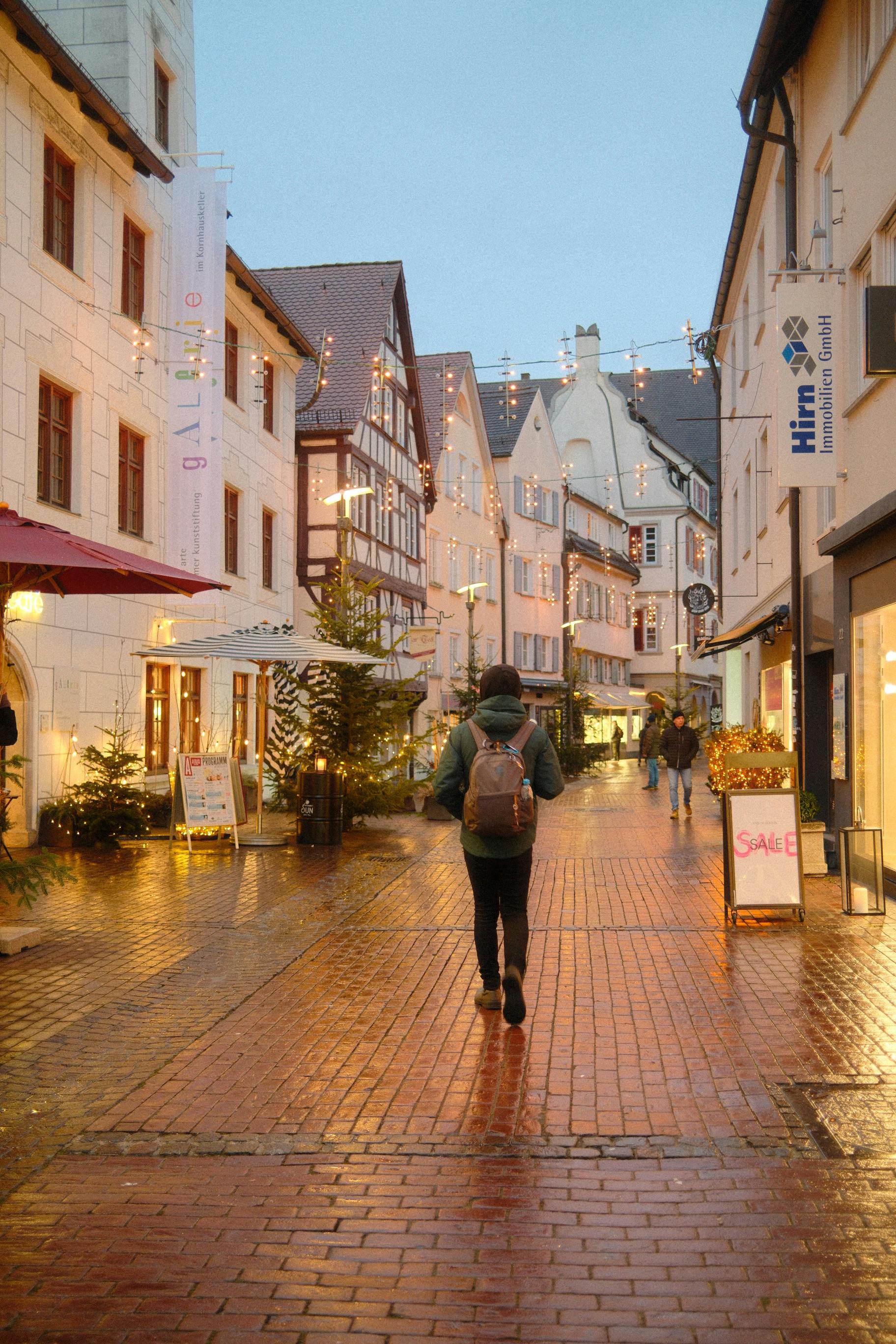 無料 お祭りの夜に、ドイツのウルムのライトアップされた歴史的な通りを歩く人。 写真素材