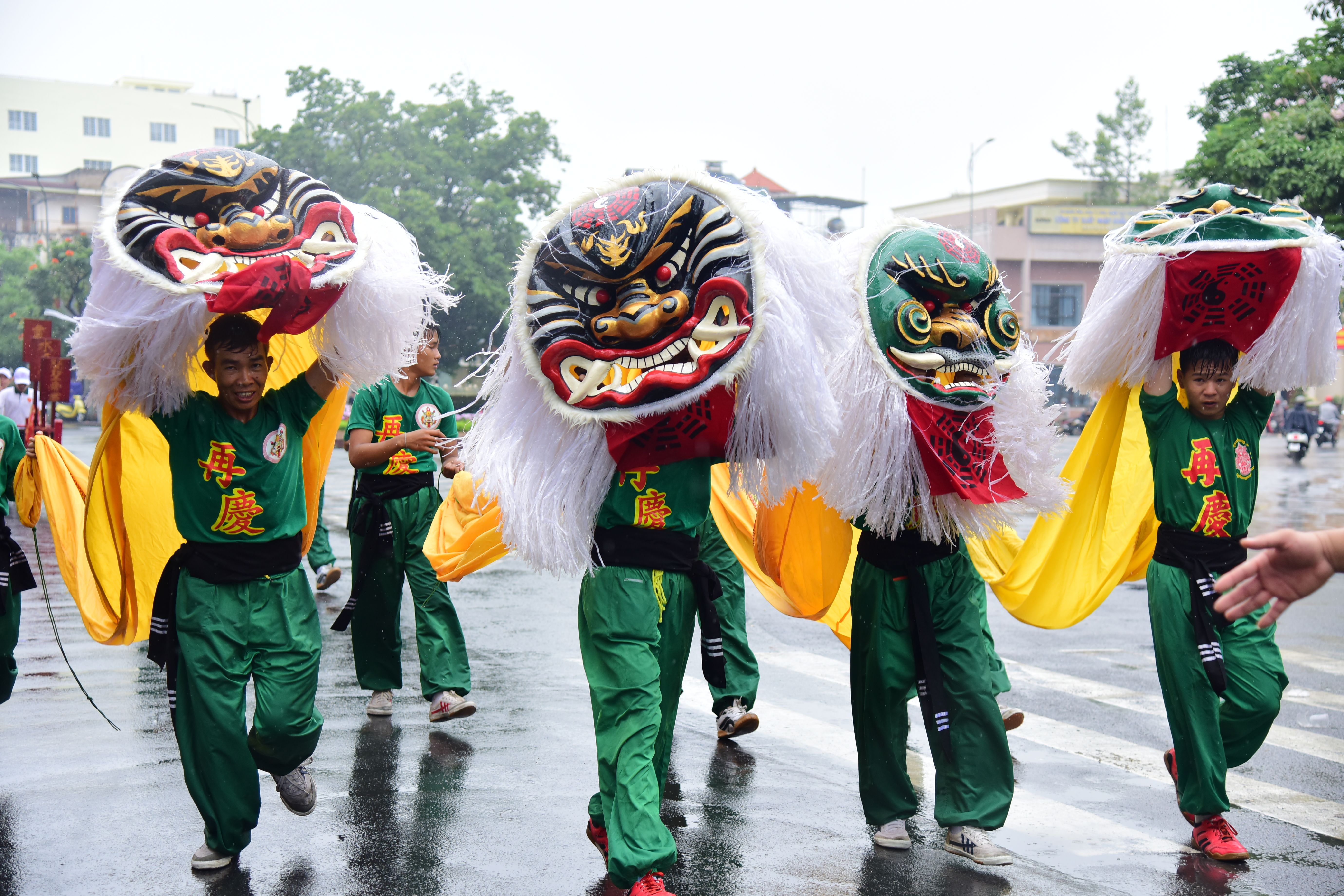 Colorful lion dance during a festive street parade with performers in traditional attire.