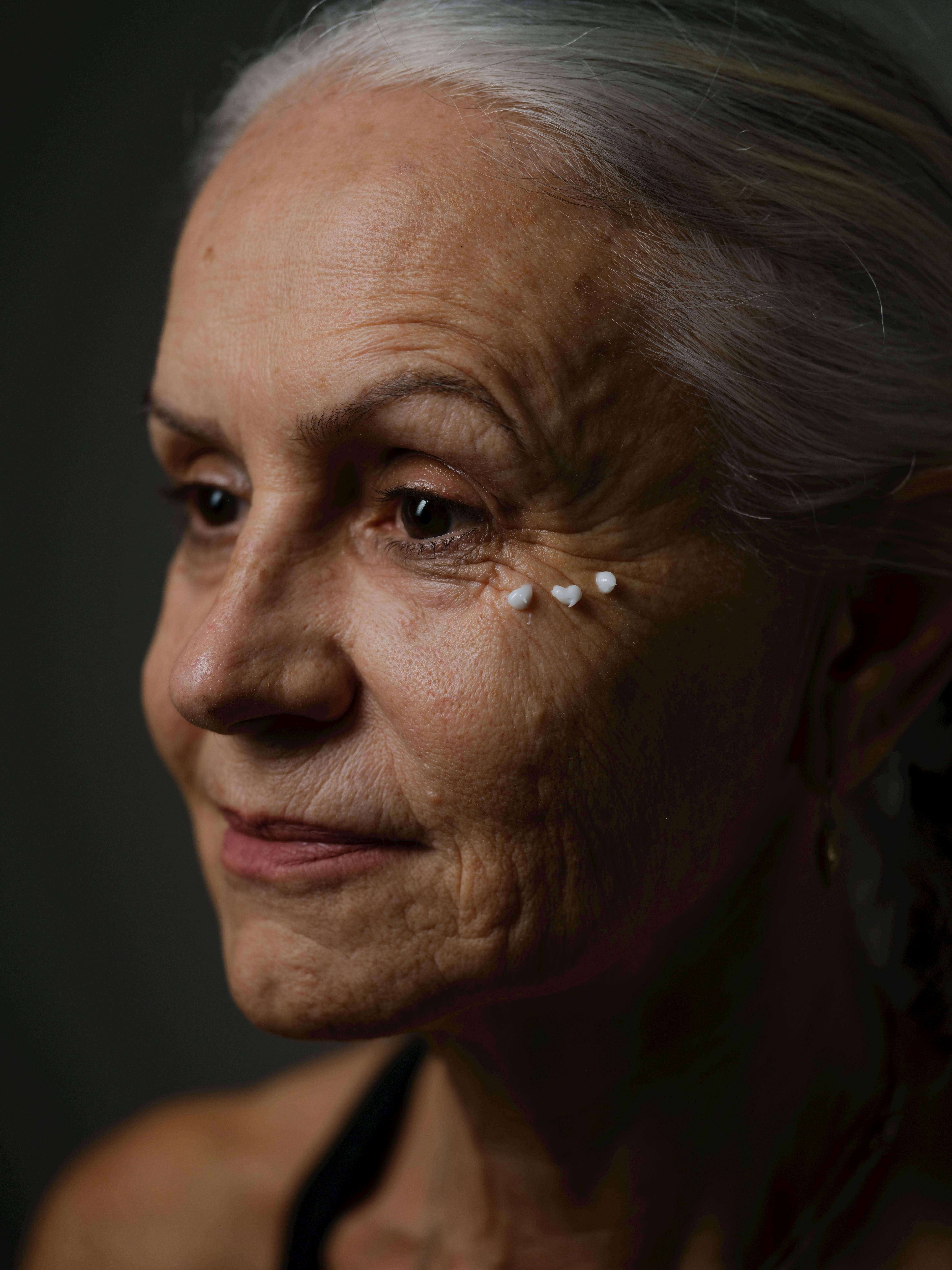 Free Artistic portrait featuring a senior woman with visible skincare elements. Captures aging gracefully. Stock Photo