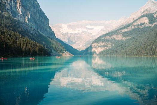 Breathtaking view of Lake Louise with canoes on a sunny summer day.
