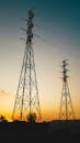 夕阳映衬着高大的输电塔，凸显了能源基础设施