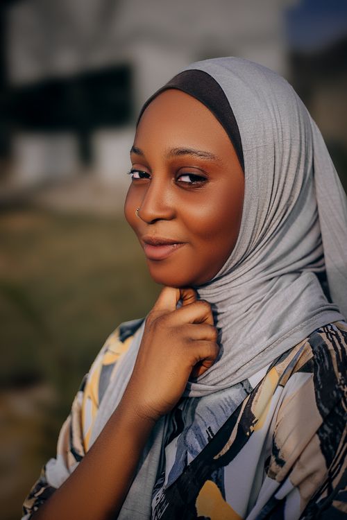 Free Close-up portrait of a woman wearing a hijab, smiling confidently outdoors. Stock Photo