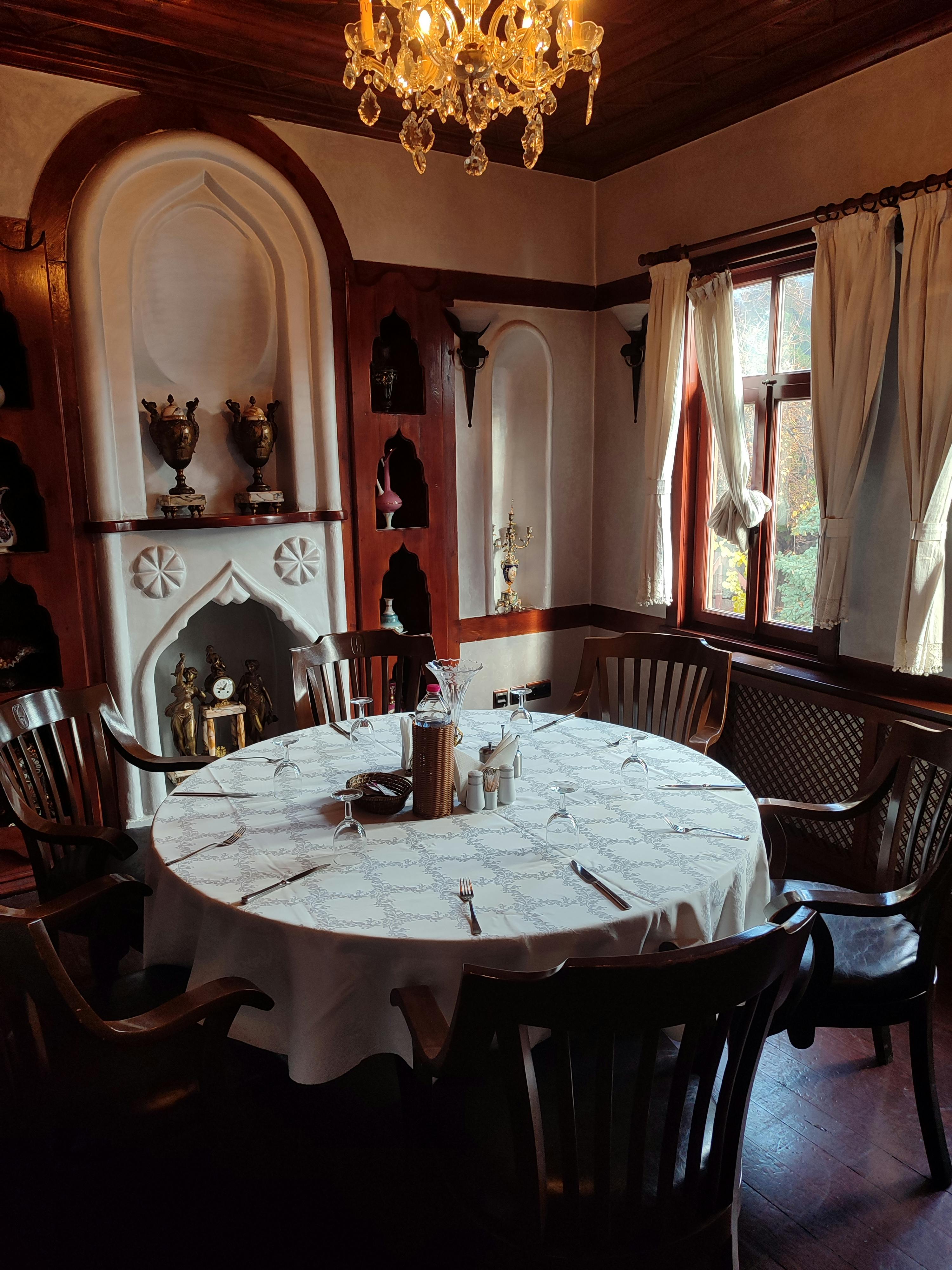 бесплатная Очаровательная столовая с винтажным декором, люстрой и элегантной сервировкой стола. Стоковое фото