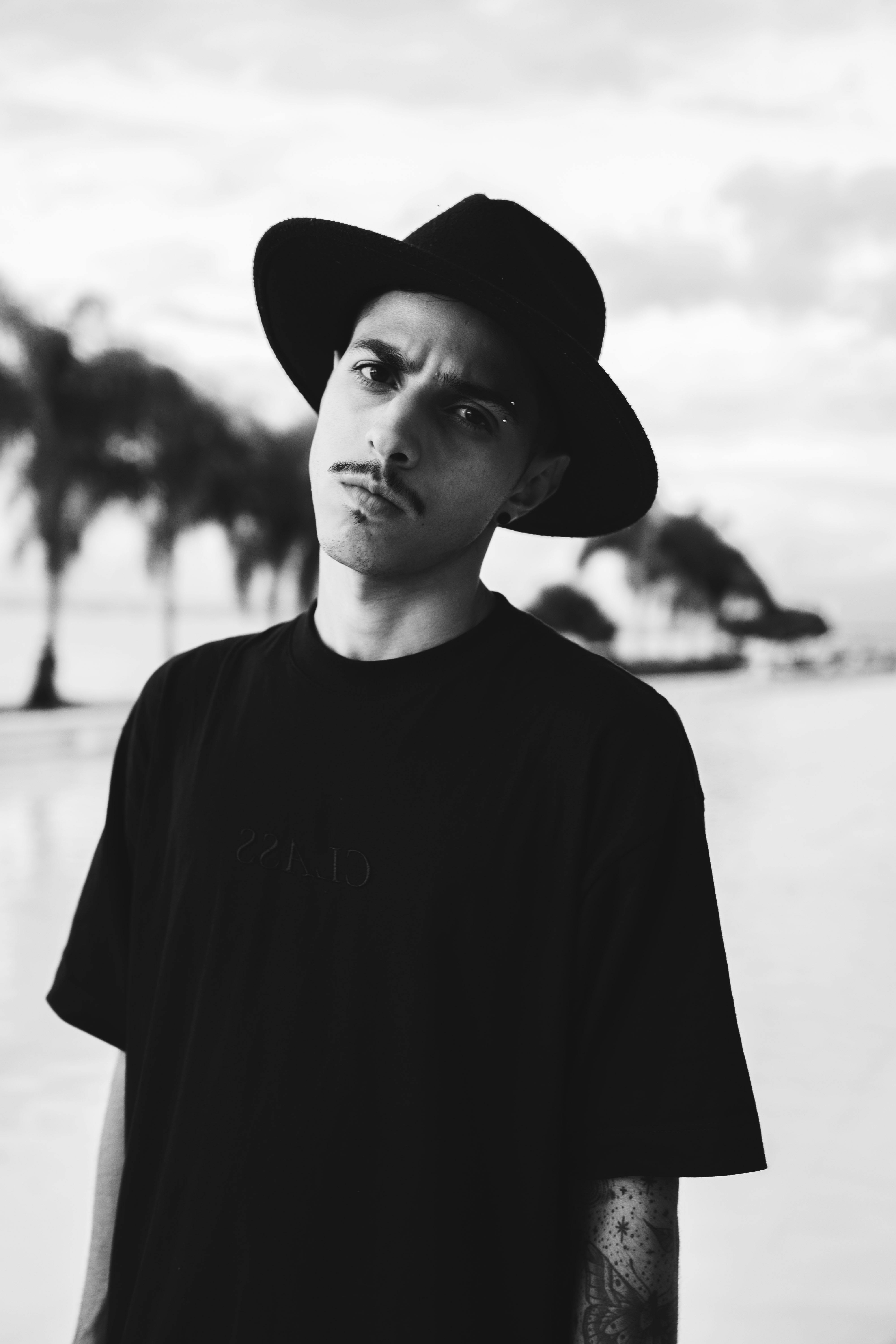 monochrome photo of a man in a round hat