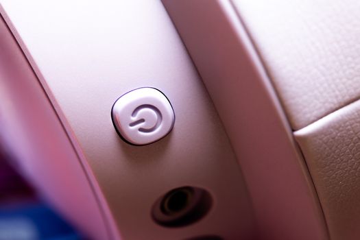 Detailed macro shot of a pink headphone power button, focus on design.