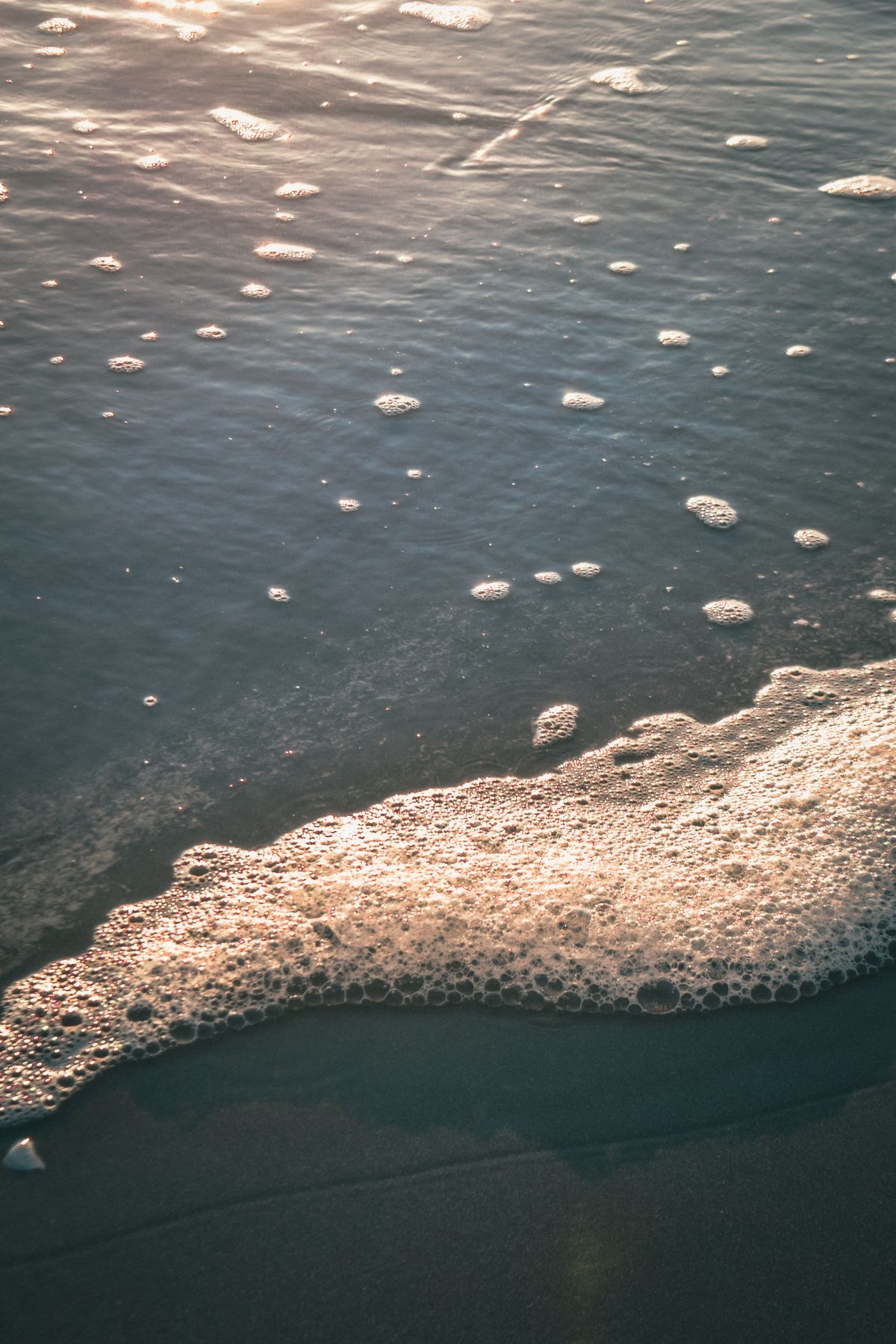 Ocean waves rolling onto a beach at the tide line