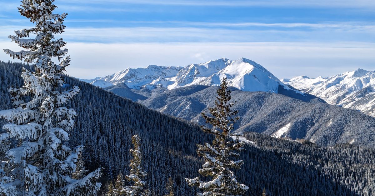 Breathtaking winter landscape of snow-covered mountains and pine trees in Aspen, Colorado.
