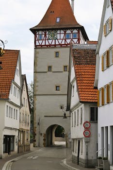 Charming street with historic tower and timber-framed buildings in Waiblingen, Germany.