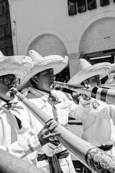 Black and white photo of Mexican musicians with traditional attire and instruments.