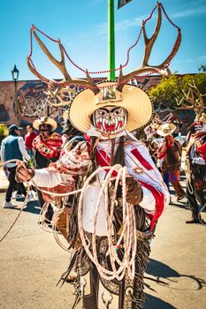 Vibrant festival scene with costumes and masks in Pachuca, Mexico.