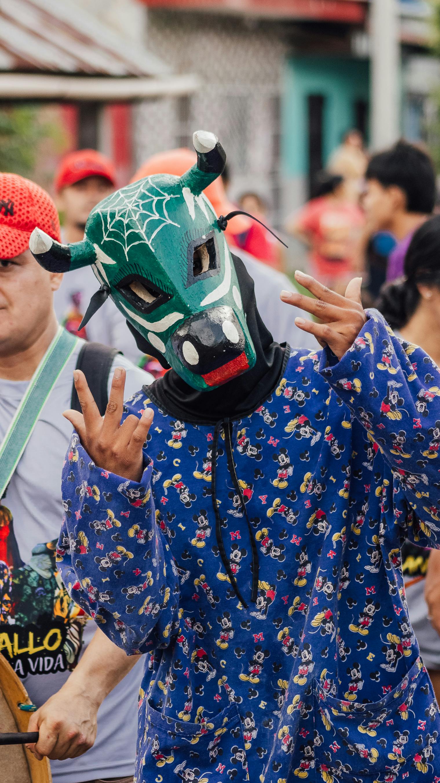 Colorful festival scene in Yurimaguas, Peru featuring a masked participant in vibrant attire celebrating.