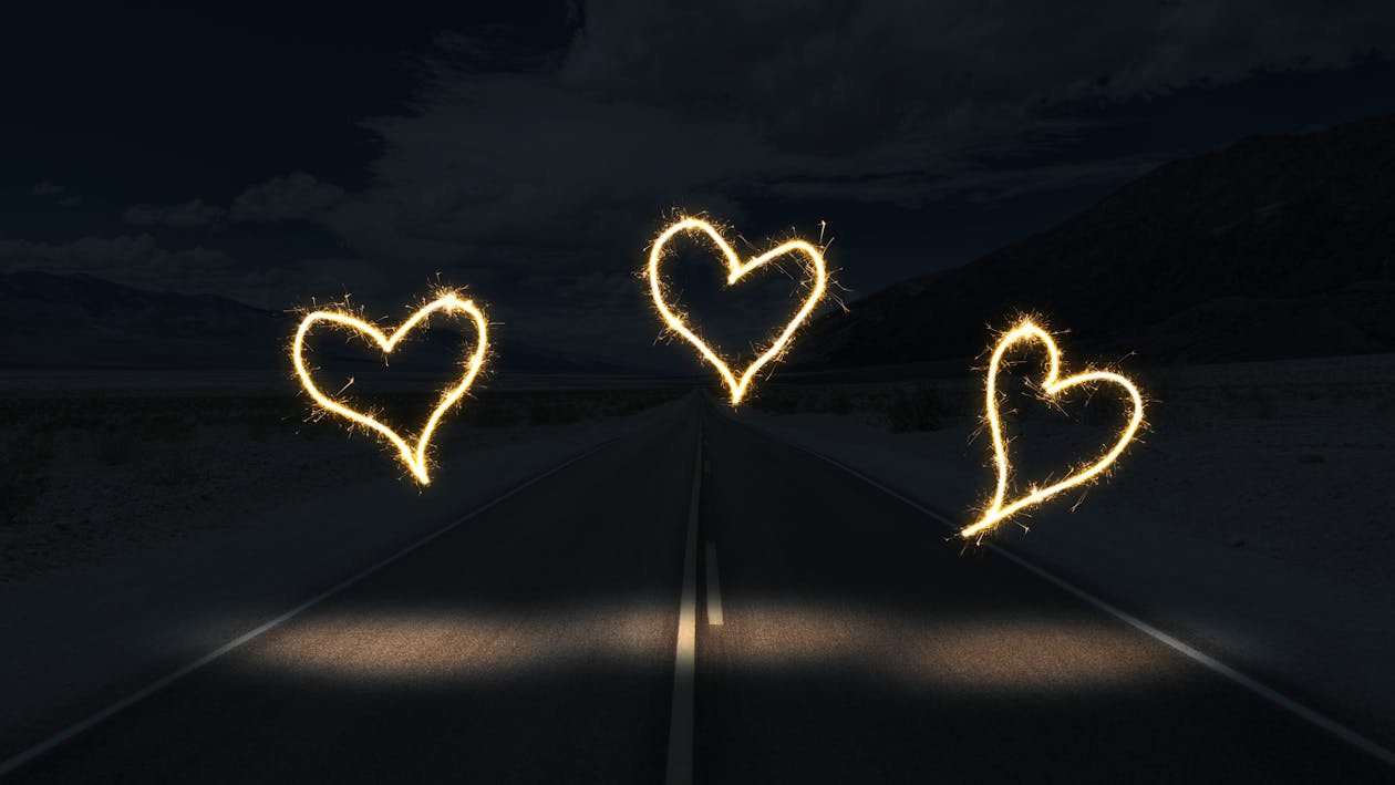 Free White Light Forming Heart on Black Surface Stock Photo
